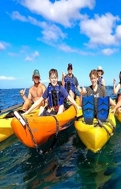 A small group paddling kayaks together on a Maui eco tour